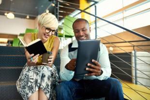 Two people happily looking at a tablet